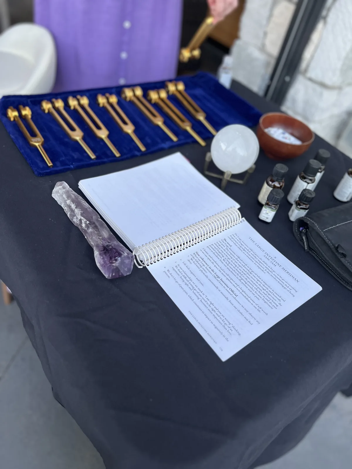 Tuning forks, crystals, and oils laid out for a sound bath session